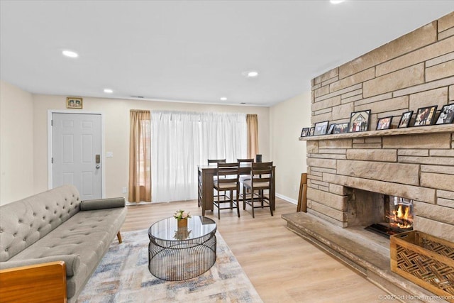 living area with recessed lighting, baseboards, wood finished floors, and a fireplace