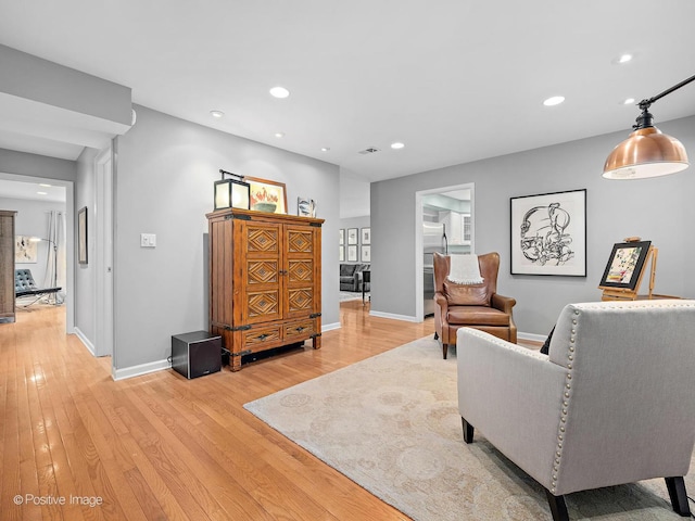 living area with light wood-style floors, baseboards, and recessed lighting