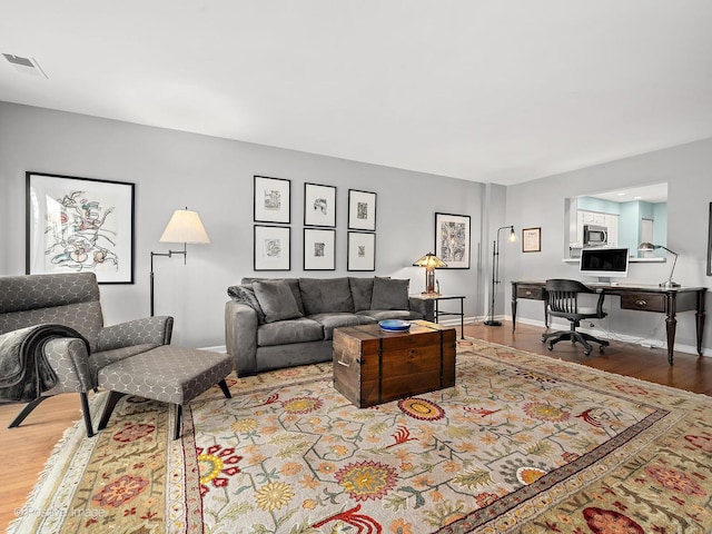living room featuring visible vents and wood finished floors