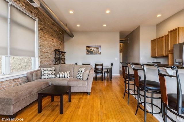 949 N Willard Ct Unit 302, Chicago, IL 60642 - living area with light wood-style floors, recessed lighting, and brick wall