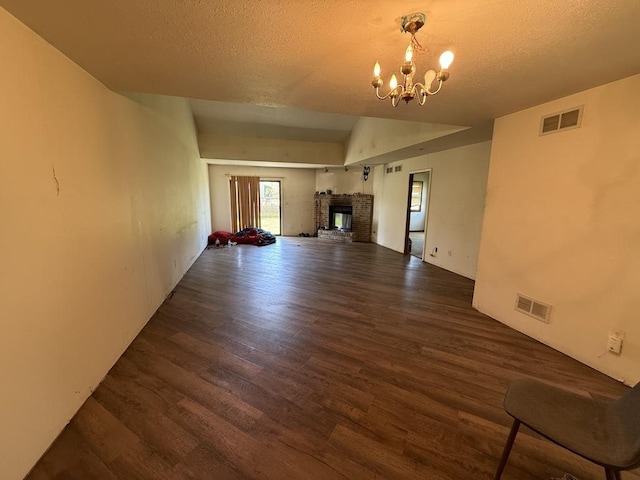 unfurnished living room with visible vents, wood finished floors, and an inviting chandelier