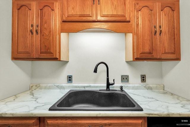 kitchen featuring a sink, black dishwasher, and brown cabinets