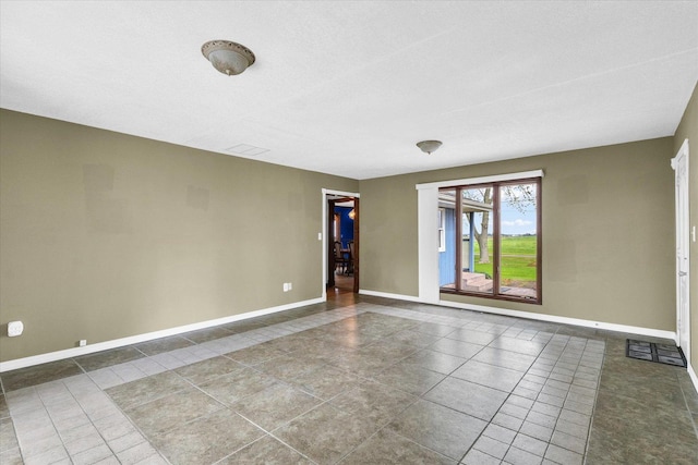 spare room featuring baseboards and tile patterned flooring