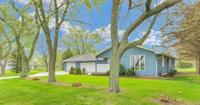 view of front of property featuring a garage, concrete driveway, and a front lawn