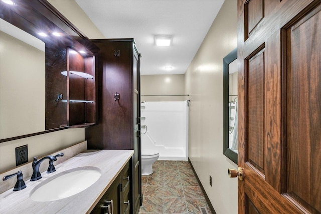 bathroom featuring toilet, walk in shower, and vanity