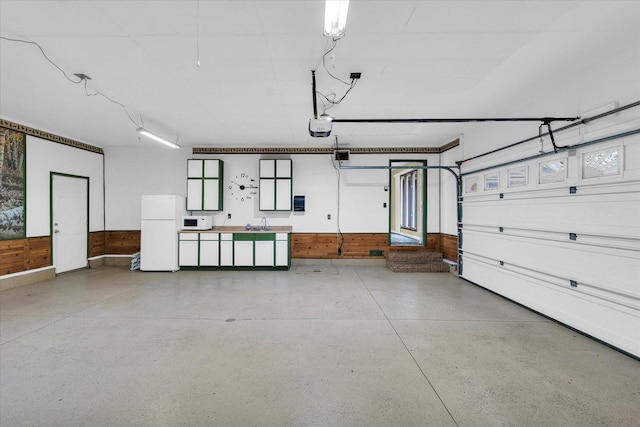 garage with freestanding refrigerator and a sink