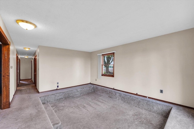 spare room featuring carpet floors and baseboards