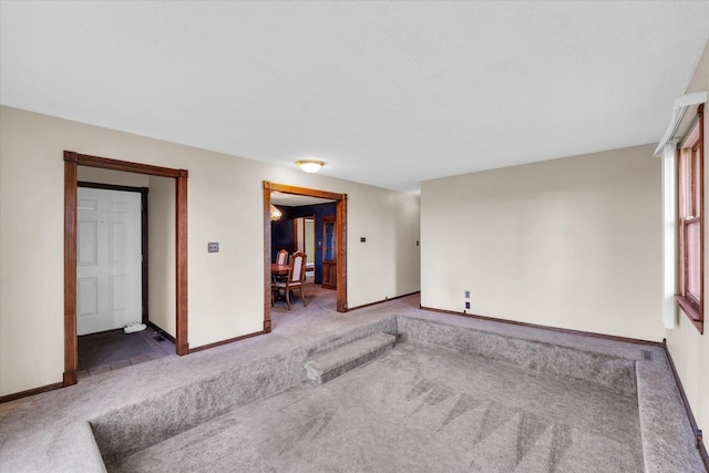 spare room with baseboards and carpet flooring