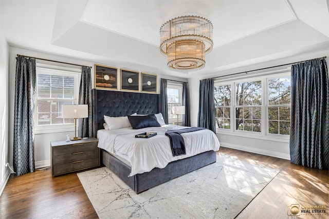 bedroom featuring baseboards, multiple windows, and a chandelier