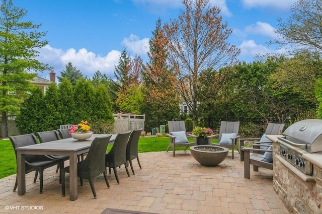 view of patio / terrace with grilling area, fence, outdoor dining area, and a fire pit