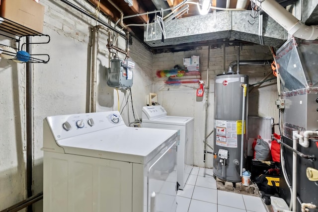 laundry room featuring washing machine and clothes dryer, laundry area, water heater, heating unit, and light tile patterned floors