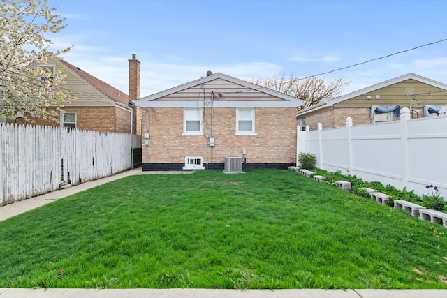 rear view of property featuring brick siding, a fenced backyard, central air condition unit, and a yard