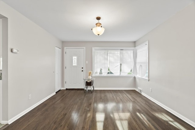 entrance foyer with visible vents, dark wood-type flooring, baseboards, and plenty of natural light