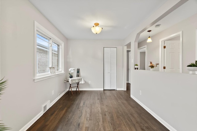 interior space featuring baseboards, dark wood-style flooring, and visible vents