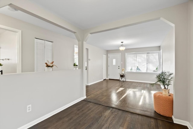 entryway with baseboards and wood finished floors