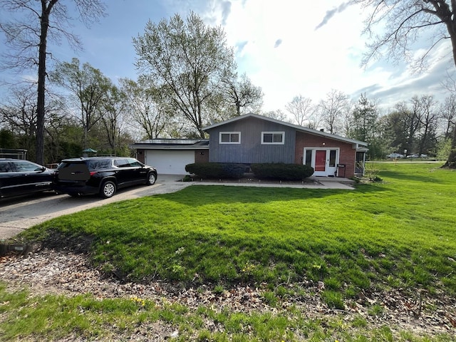 view of front of property with brick siding, driveway, a front lawn, and a garage