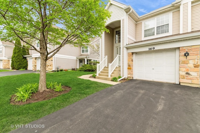 view of front facade with an attached garage, driveway, stone siding, and a front lawn