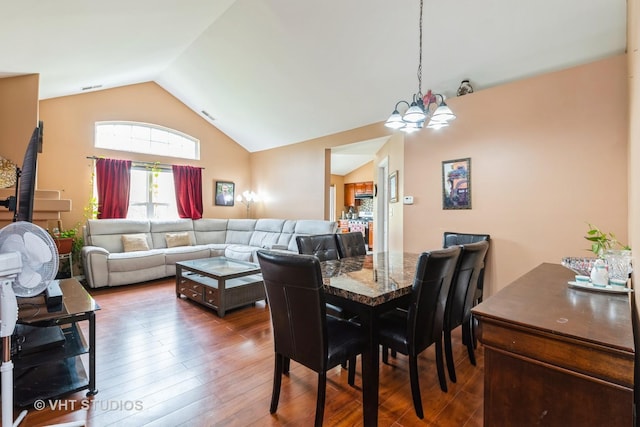 dining area with visible vents, a chandelier, lofted ceiling, and hardwood / wood-style floors