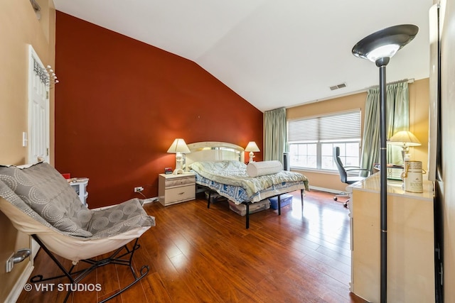 bedroom featuring baseboards, lofted ceiling, wood finished floors, and visible vents