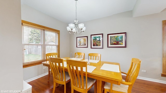 dining room with a chandelier, baseboards, and wood finished floors