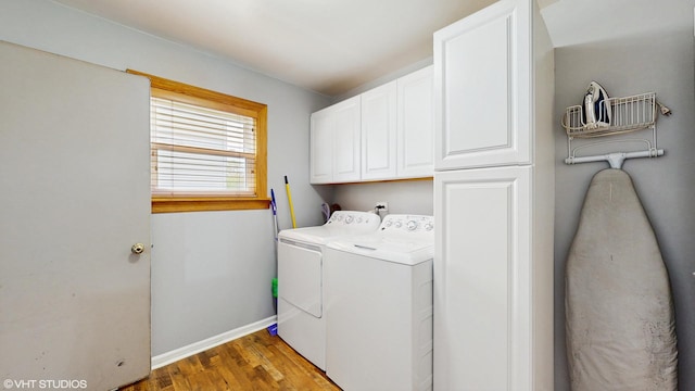 clothes washing area featuring light wood-style flooring, cabinet space, baseboards, and washer and dryer