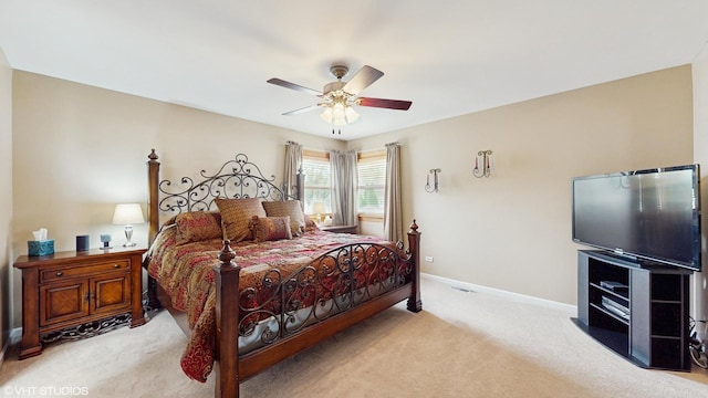 bedroom featuring light colored carpet, baseboards, and a ceiling fan