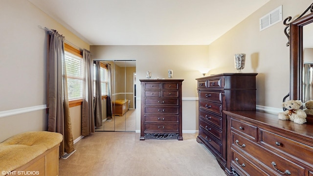 bedroom with light colored carpet, baseboards, a closet, and visible vents