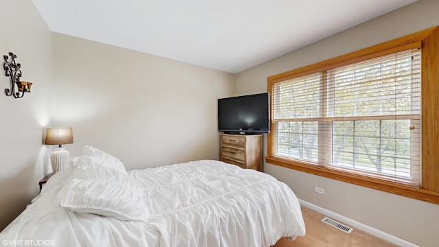 bedroom with baseboards, multiple windows, visible vents, and carpet