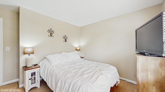 bedroom with baseboards and light carpet
