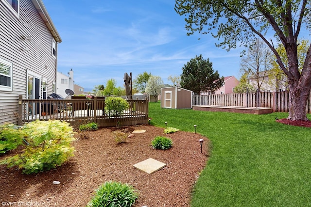 view of yard featuring a storage unit, an outdoor structure, a fenced backyard, and a wooden deck