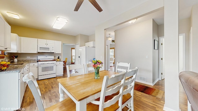 dining area featuring a ceiling fan, baseboards, visible vents, and light wood-type flooring