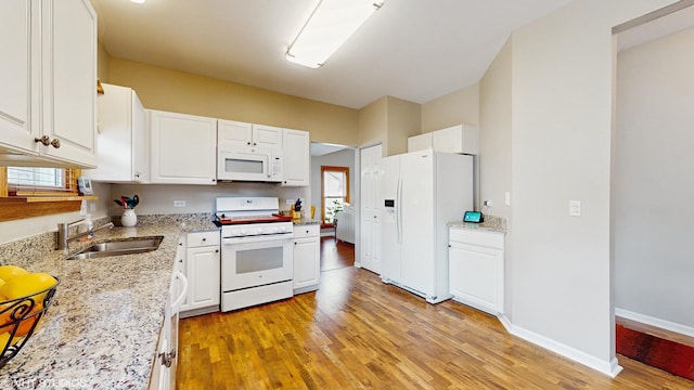 kitchen with white cabinetry, white appliances, light wood finished floors, and a sink