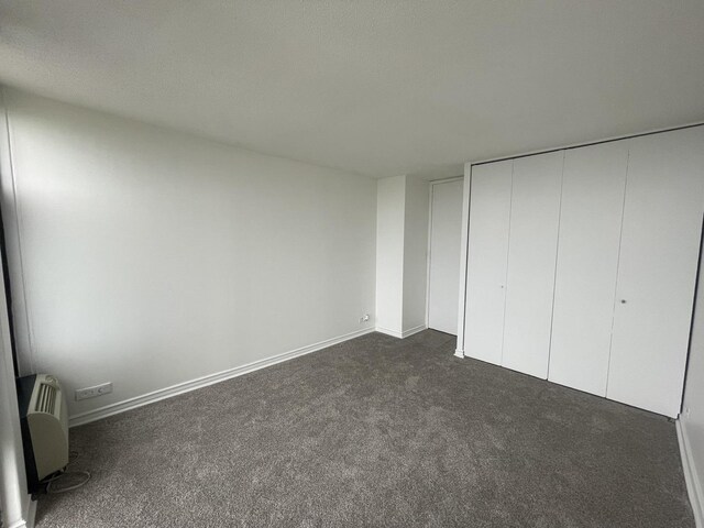 6700 S S Shore Dr Unit 21B, Chicago, IL 60649 - unfurnished bedroom with dark colored carpet, a closet, and baseboards