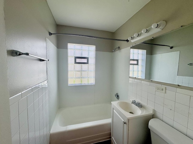 bathroom with toilet, tile walls, a wealth of natural light, and shower / bathing tub combination