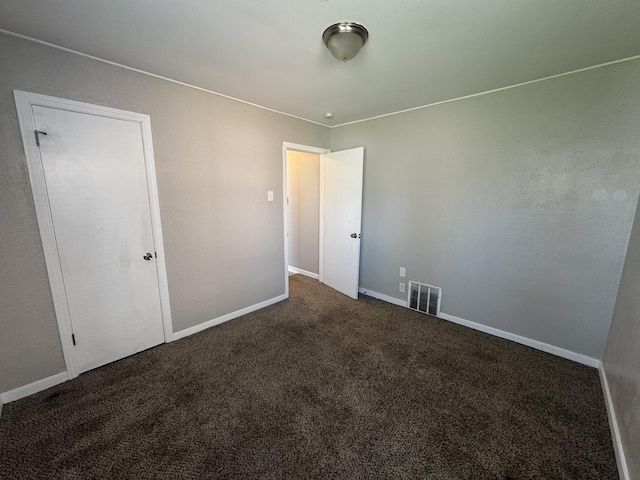 unfurnished bedroom featuring carpet floors, baseboards, and visible vents