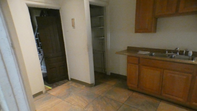 1910 S Spaulding Ave, Chicago, IL 60623 - kitchen with a sink, light tile patterned floors, and brown cabinets