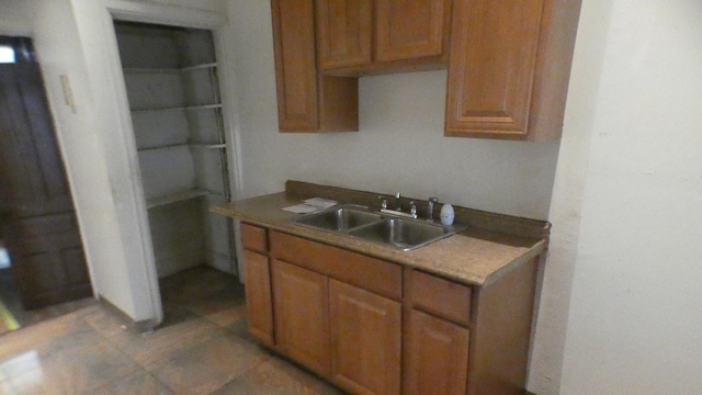 1910 S Spaulding Ave, Chicago, IL 60623 - kitchen featuring brown cabinets, light tile patterned flooring, and a sink