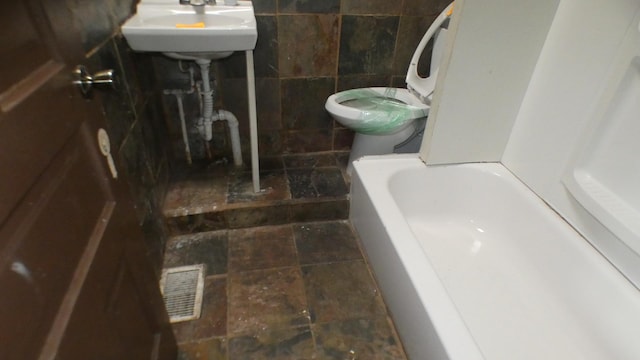 1910 S Spaulding Ave, Chicago, IL 60623 - full bath with toilet, visible vents, a sink, and tile walls