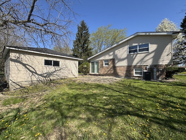 back of house with a lawn, brick siding, and cooling unit