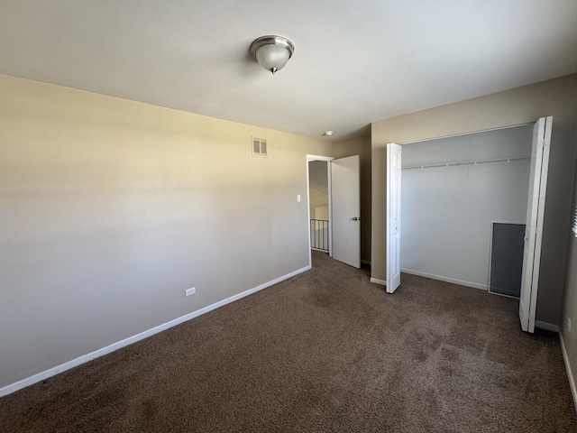 unfurnished bedroom featuring baseboards, visible vents, carpet, and a closet