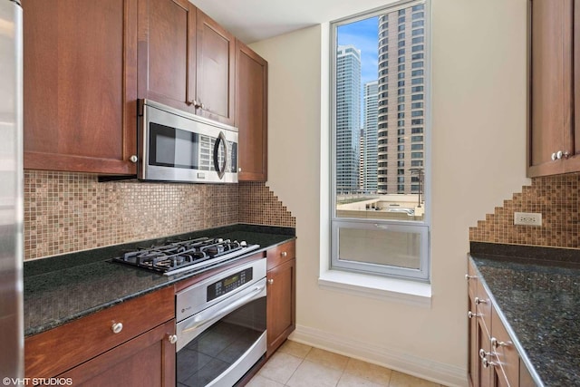 600 N Lake Shore Dr Unit 1309, Chicago, IL 60611 - kitchen with baseboards, light tile patterned floors, dark stone countertops, tasteful backsplash, and appliances with stainless steel finishes