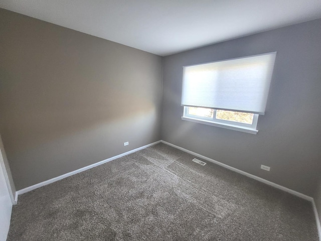carpeted empty room with visible vents and baseboards