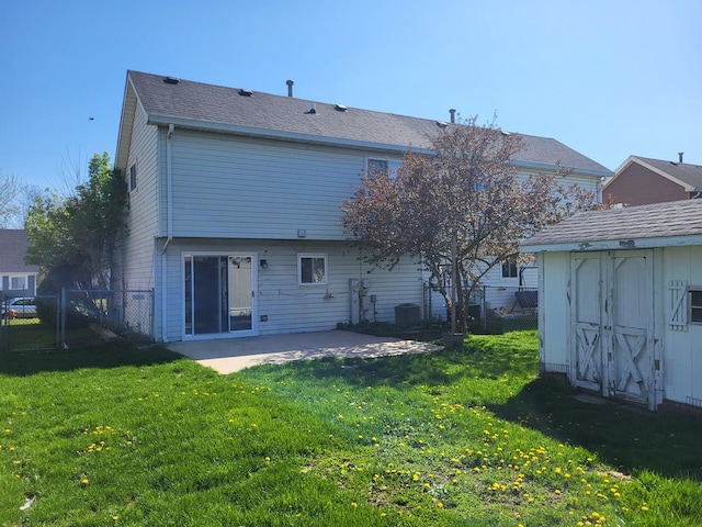 back of house with fence, a patio, a lawn, and a storage shed