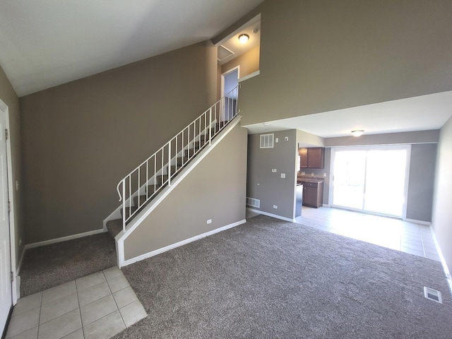 unfurnished living room with stairway, light colored carpet, light tile patterned floors, and visible vents
