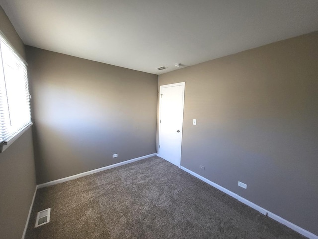 unfurnished room featuring baseboards, carpet, and visible vents