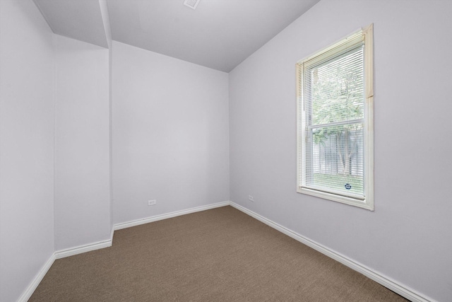unfurnished room with dark colored carpet and baseboards