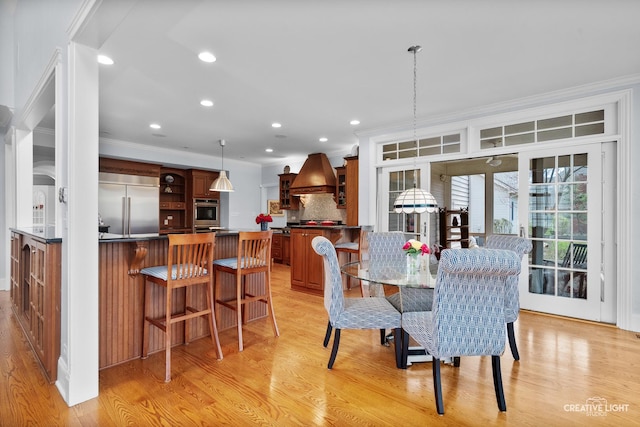 dining space featuring light wood-style floors, ornamental molding, and recessed lighting