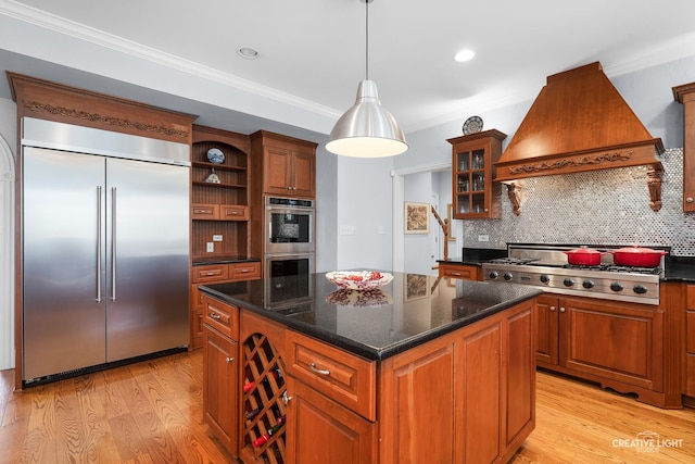 kitchen featuring premium range hood, a kitchen island, stainless steel appliances, and light wood finished floors
