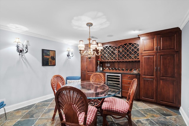 dining area with crown molding, a notable chandelier, stone tile floors, baseboards, and wine cooler