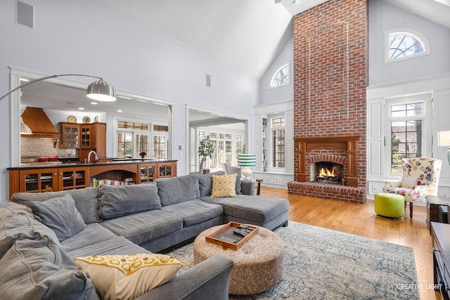 living room with plenty of natural light, wood finished floors, and high vaulted ceiling